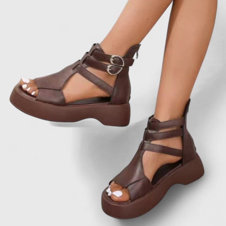 Close-up of Nova platform sandal ankle buckle closure and crossed strap design in black