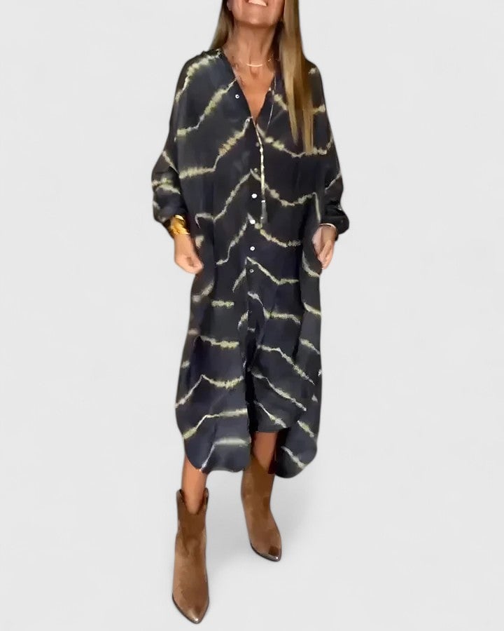 Woman wearing the Nova black tie-dye button-down midi shirt dress with charcoal and gold wave print, fully buttoned with ankle boots