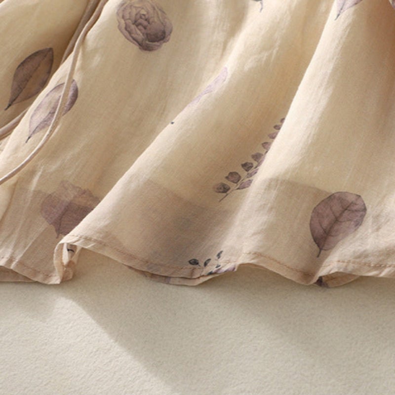 Full-length shot of a woman in a cream embroidered blouse tucked into a midi skirt