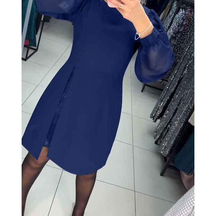 Model smiling in the Nyla elegant timeless dress in marine blue at an outdoor event