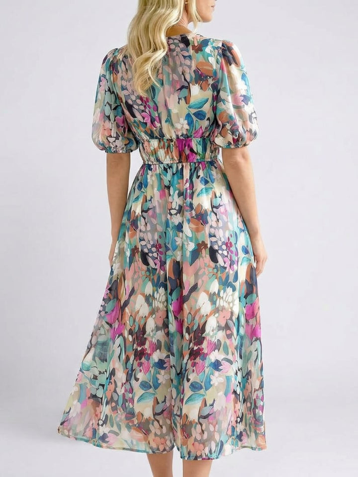 Close-up of the Octavia floral midi dress showing V-neckline detail and colorful botanical print fabric