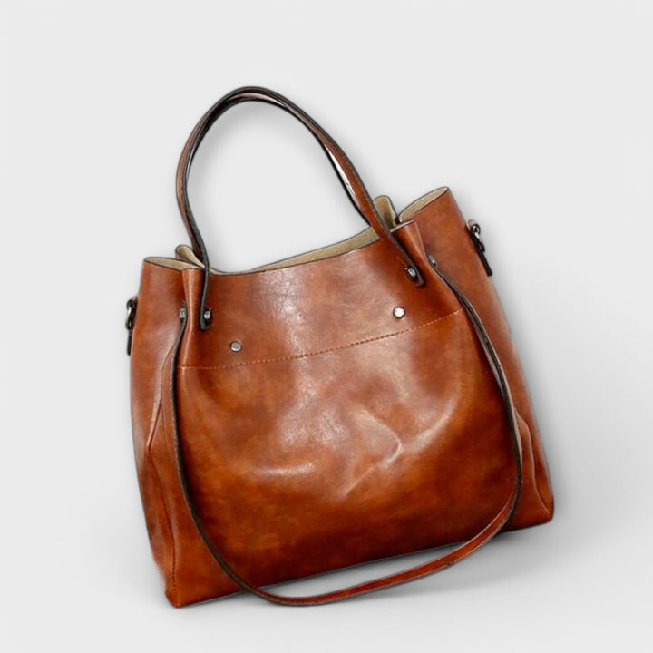 Olivia clutch bag in red held in model's hand showing compact elegant design
