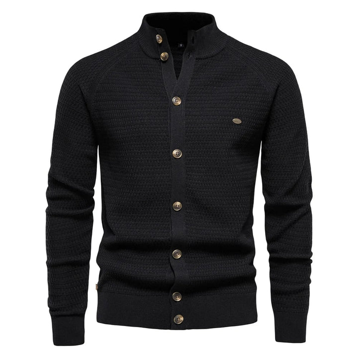 Model styling the cable-knit vest in black over a casual white tee for a relaxed everyday outfit