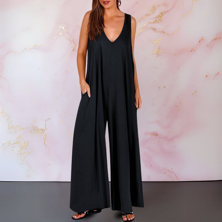 Woman wearing a black sleeveless V-neck wide-leg jumpsuit with side pockets, front view