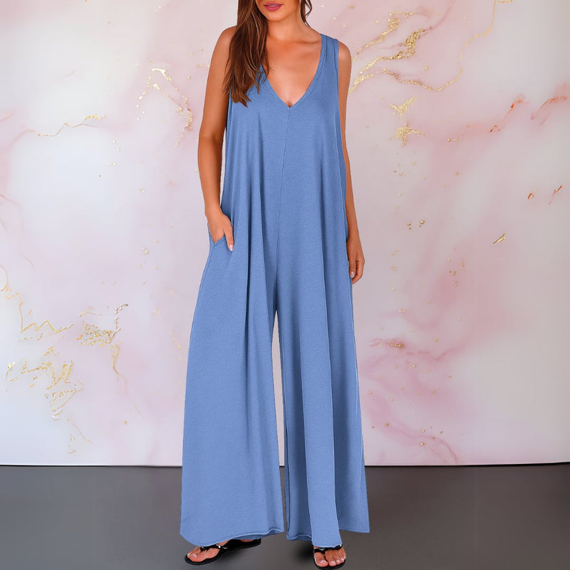 Side view showing the flowing wide-leg silhouette and hidden side pocket of a black jumpsuit