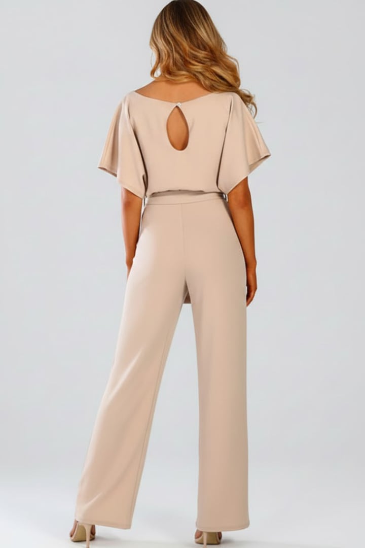 Back view of woman in beige wide leg short sleeve jumpsuit showing relaxed silhouette