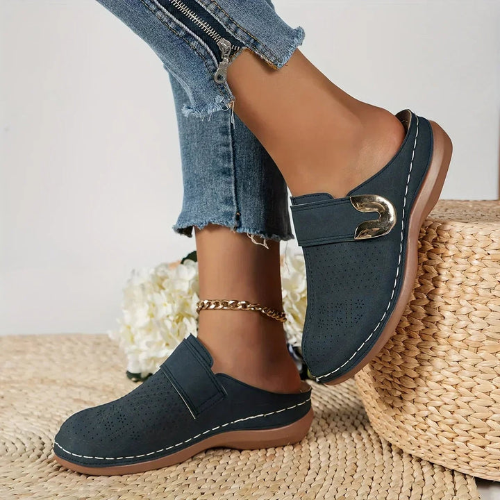 Flat lay of all four Ophelia wedge sandal color options: black, navy blue, pale pinkish grey, and light brown