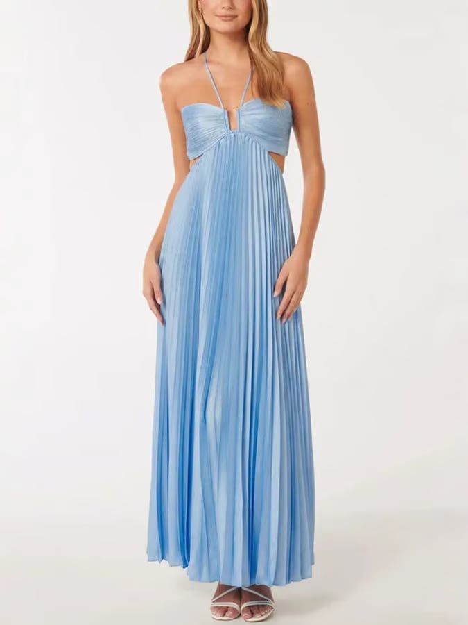 Side view of a woman in a flowing blue halter maxi dress showing the elongated silhouette