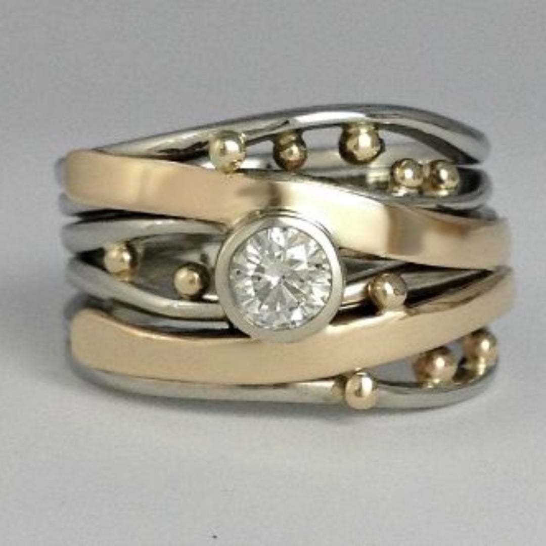 Vintage gold intarsia ring with sparkling zirconia stones on a neutral background