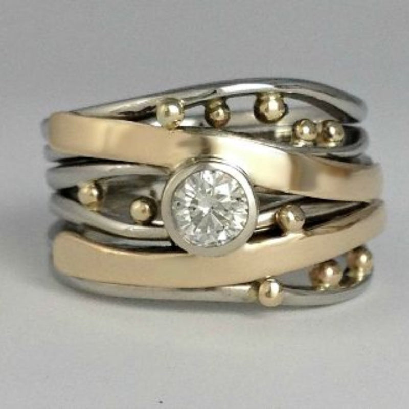 Vintage gold intarsia ring with sparkling zirconia stones on a neutral background