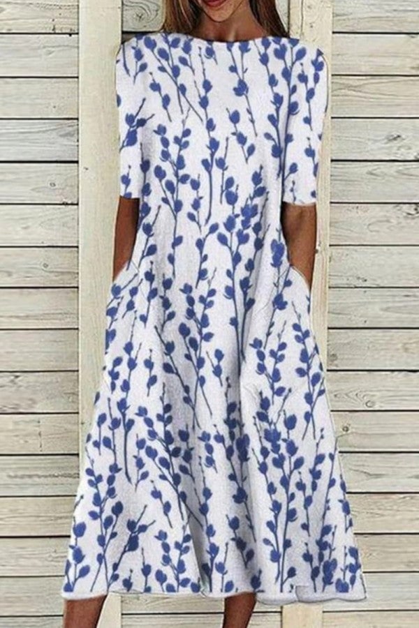 Woman wearing a flowy blue floral crew neck half sleeve dress with a gently flared skirt