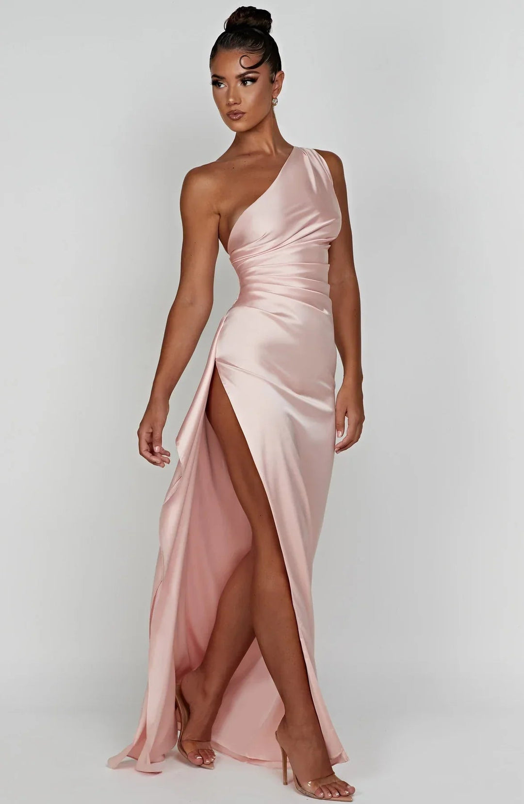 Model wearing beige one-shoulder formal dress at an evening event