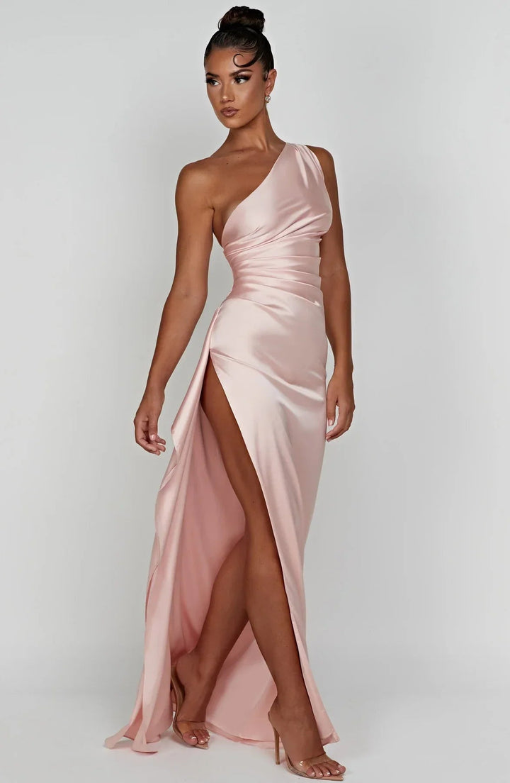 Model wearing beige one-shoulder formal dress at an evening event