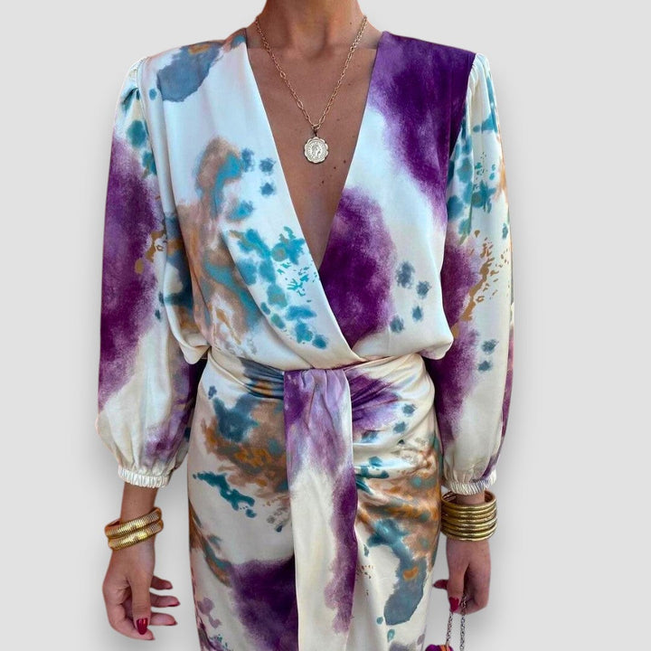 Model wearing a floral wrap blouse and flowing high-waisted midi skirt set in a delicate print, front view