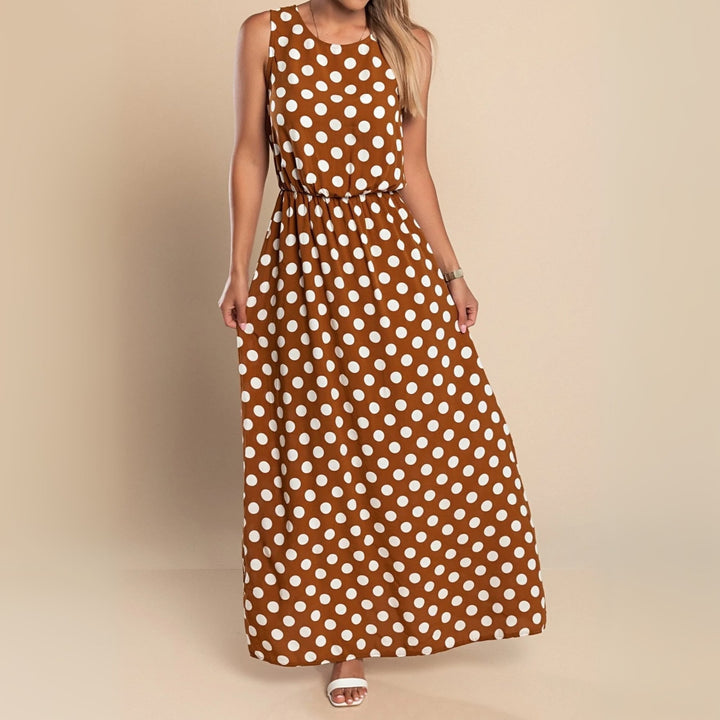 Woman wearing a flowing brown polka dot maxi dress in a garden setting