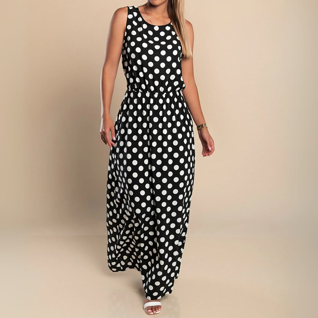 Side profile of model wearing a flattering black polka dot maxi dress