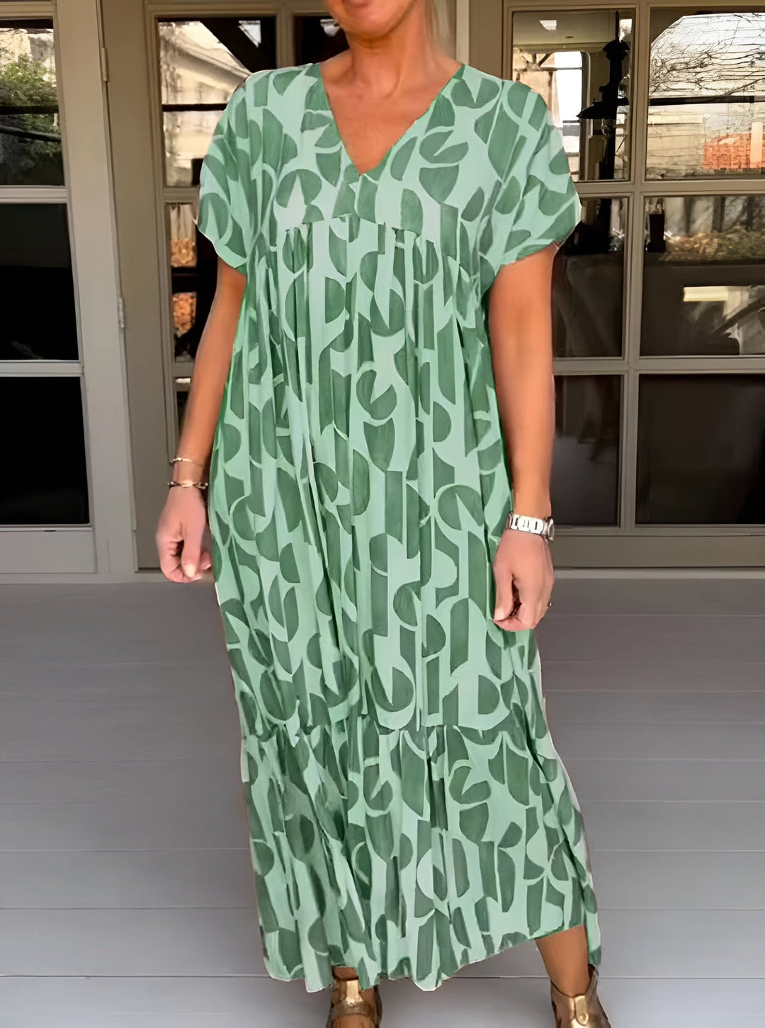 Front view of a green flowy V-neck midi dress showing the draped fabric detail