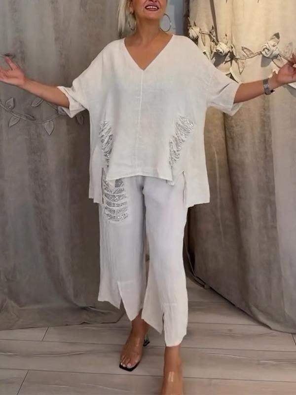 Woman wearing the Pearl white linen V-neck oversized top and cropped wide-leg pants set with sequin fringe pocket detail