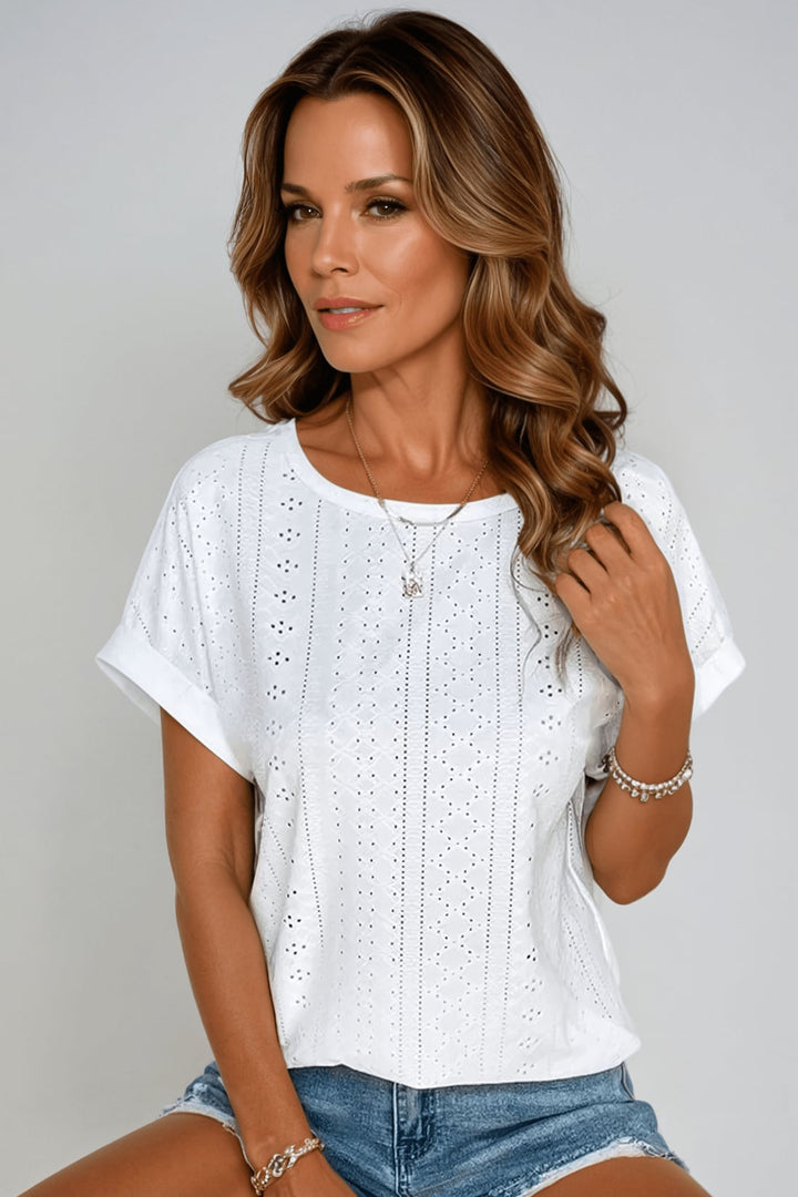 Woman wearing a white eyelet embroidered crew neck short sleeve top with a relaxed boxy fit, front view