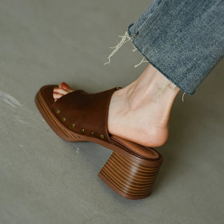 Close-up of Penelope flat sandal strap and buckle detail in brown