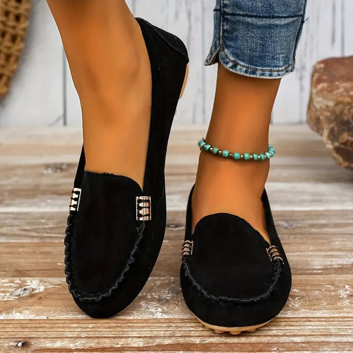 Women's Penny suede-look slip-on loafer in black with gold-tone hardware and contrast topstitching, flat sole, front view