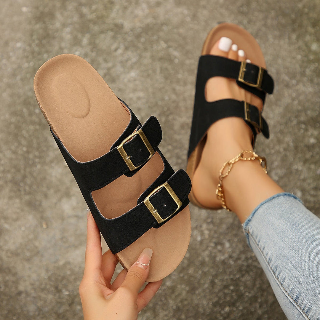 Side profile view of Persephone women's black open-toe flat sandals highlighting the cushioned footbed