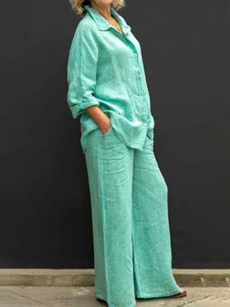 Woman styling the Petra two-piece set belted at the waist in green linen fabric