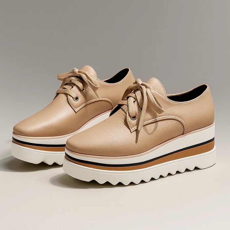 Petra platform Oxford lace-up wedge sneaker in beige with striped cream, tan, and black sole, front three-quarter view