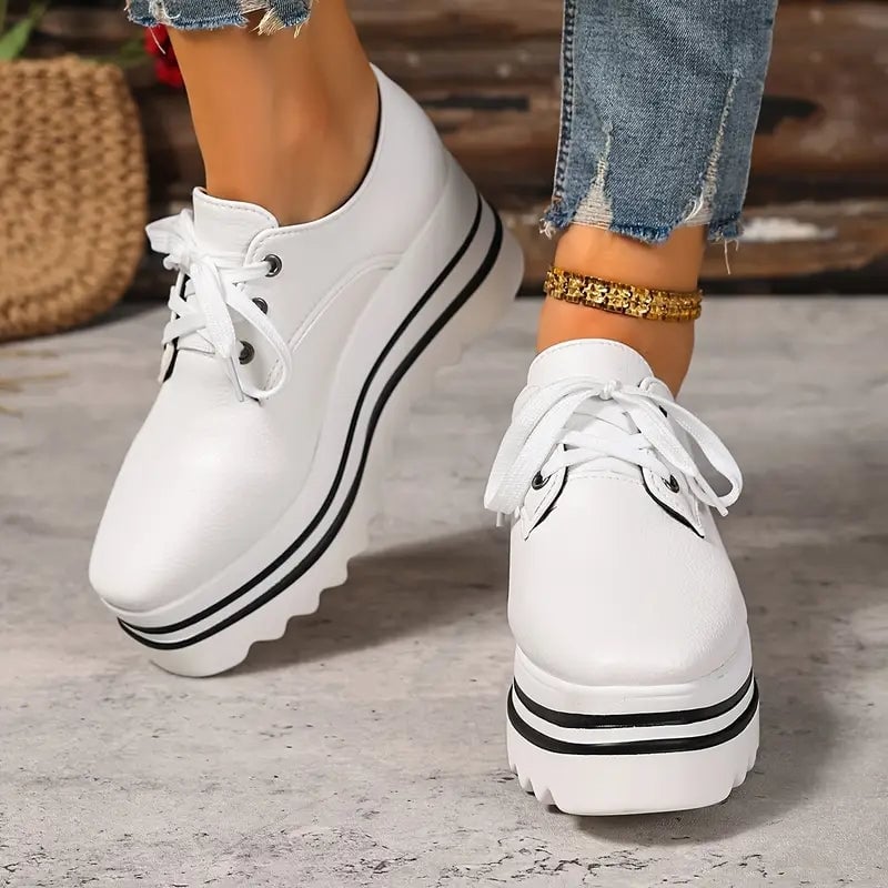 Pair of Petra platform Oxford lace-up wedge sneakers styled with casual outfit, all three color options