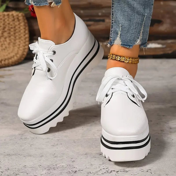Pair of Petra platform Oxford lace-up wedge sneakers styled with casual outfit, all three color options
