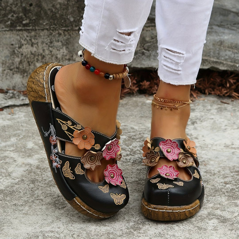 Phoebe women's wedge sandals in black shown from a front three-quarter angle highlighting the wedge sole and strappy upper