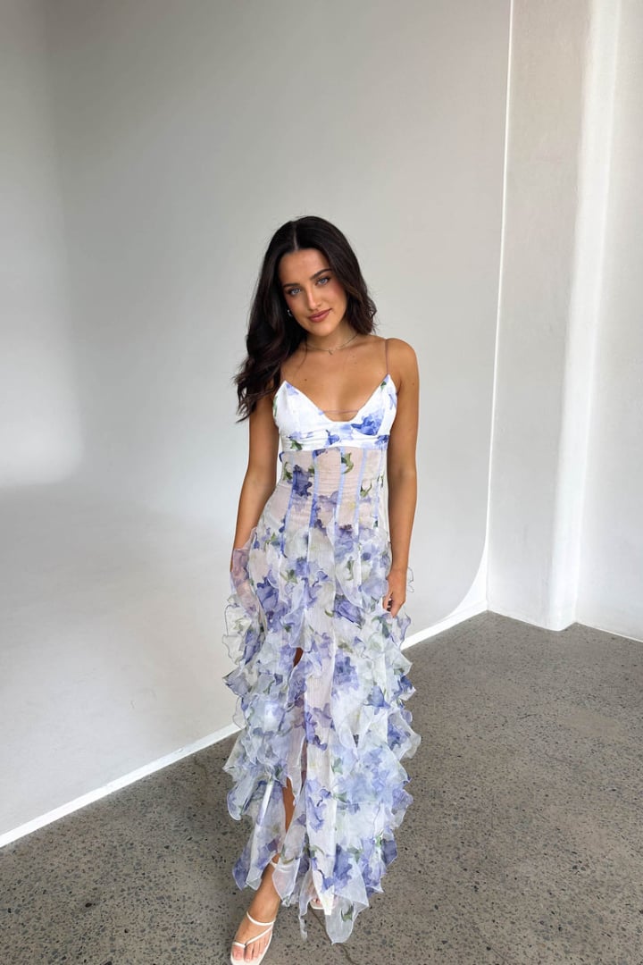 Full-length lifestyle shot of model wearing the Pippa maxi dress in blue and white outdoors