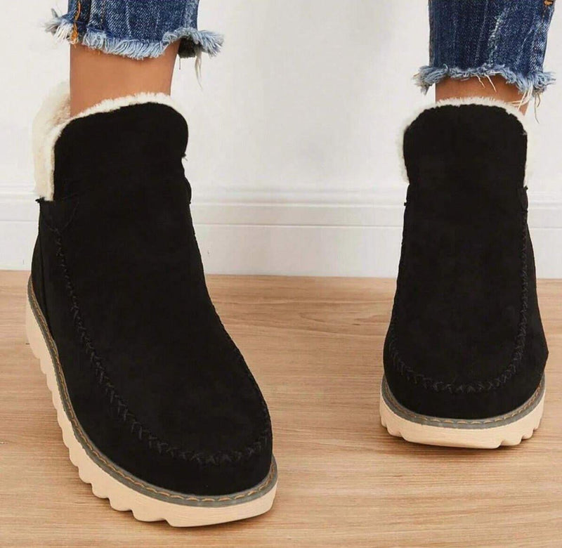 PolarBelle winter boots in brown styled with dark skinny jeans on a snowy background