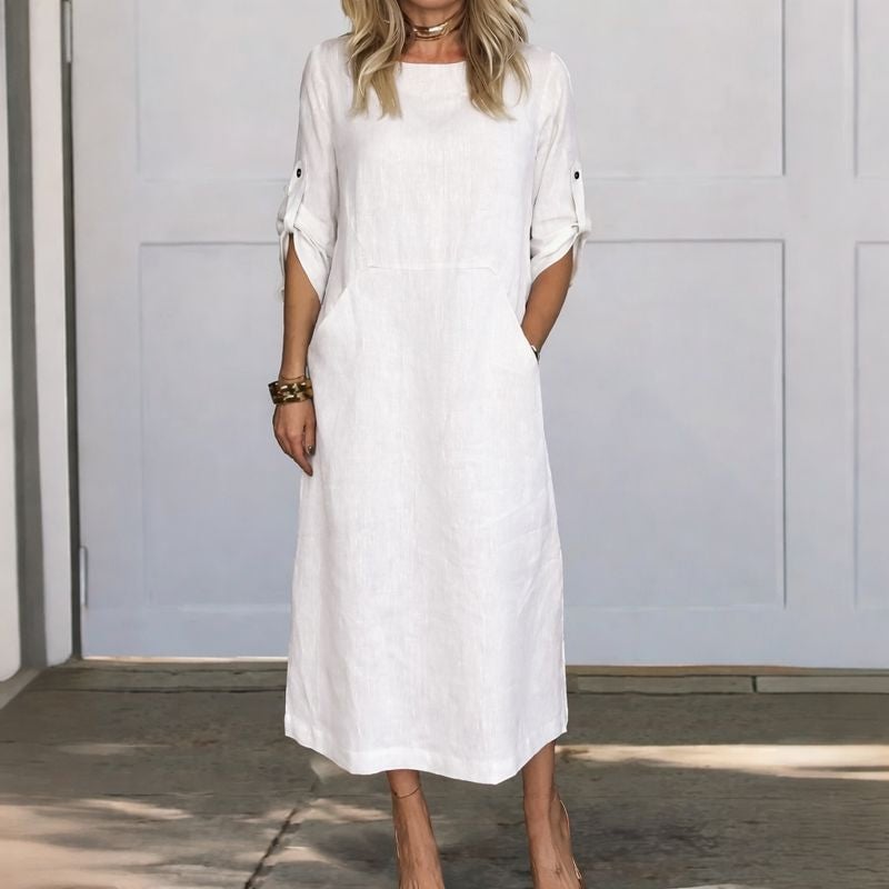 Woman wearing the Poppy A-line draped loose fit dress in a relaxed coastal setting