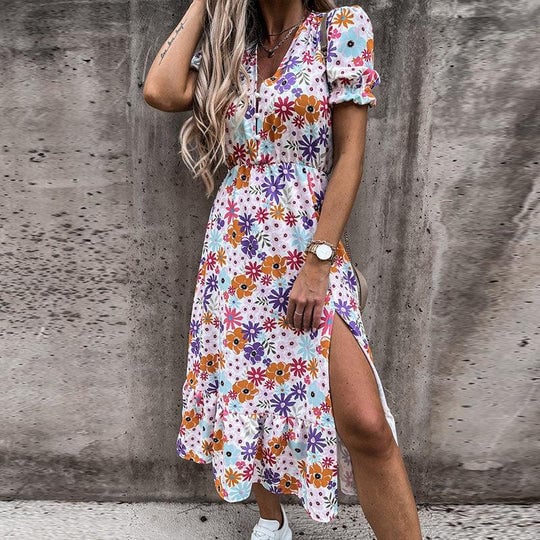 Front view of the Poppy floral midi dress in purple showing the smocked elastic waist and flowing midi skirt with side split