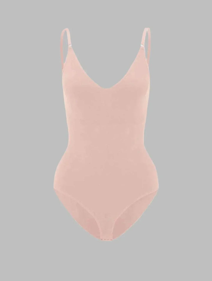 Model wearing the PowerSculpt bodysuit in white under light-colored clothing demonstrating invisible finish