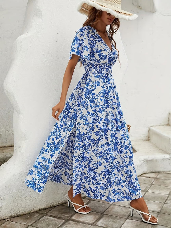 Model wearing the Primrose flowy dress styled with sandals on a sunny beach
