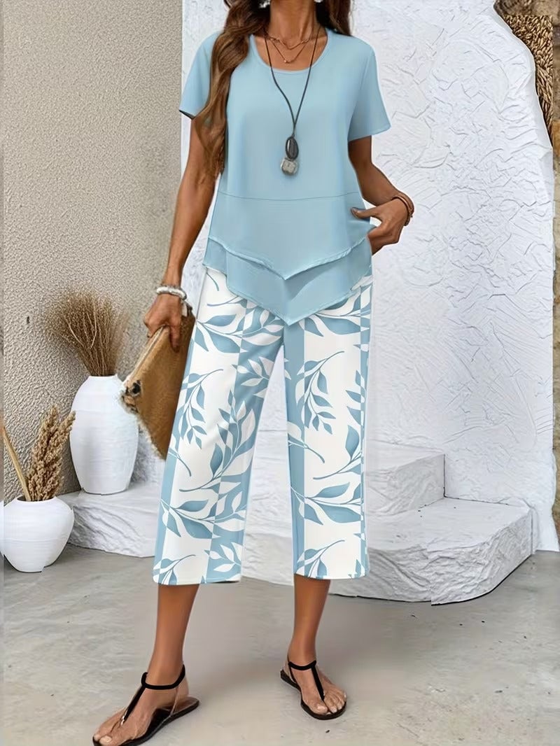 Front view of women's leaf print coordinated set in purple with short-sleeve top and wide-leg pants