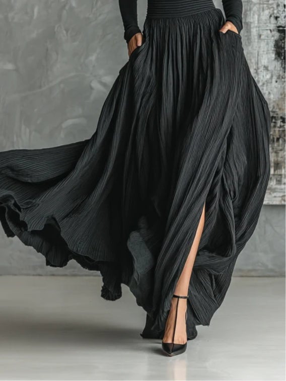 Close-up detail of black pleated skirt and slim turtleneck top from coordinated women's set