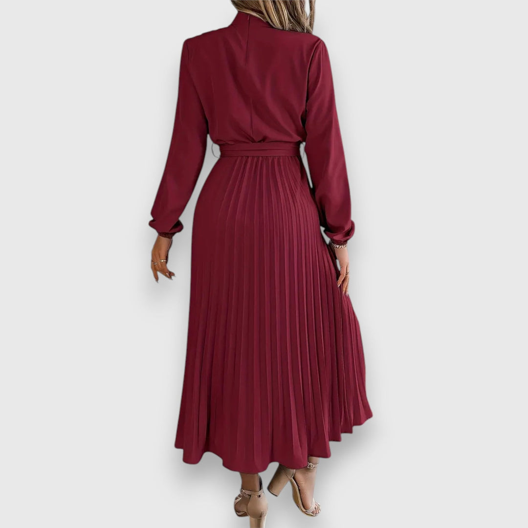 Flat lay of elegant pleated midi dress in beige highlighting fabric texture