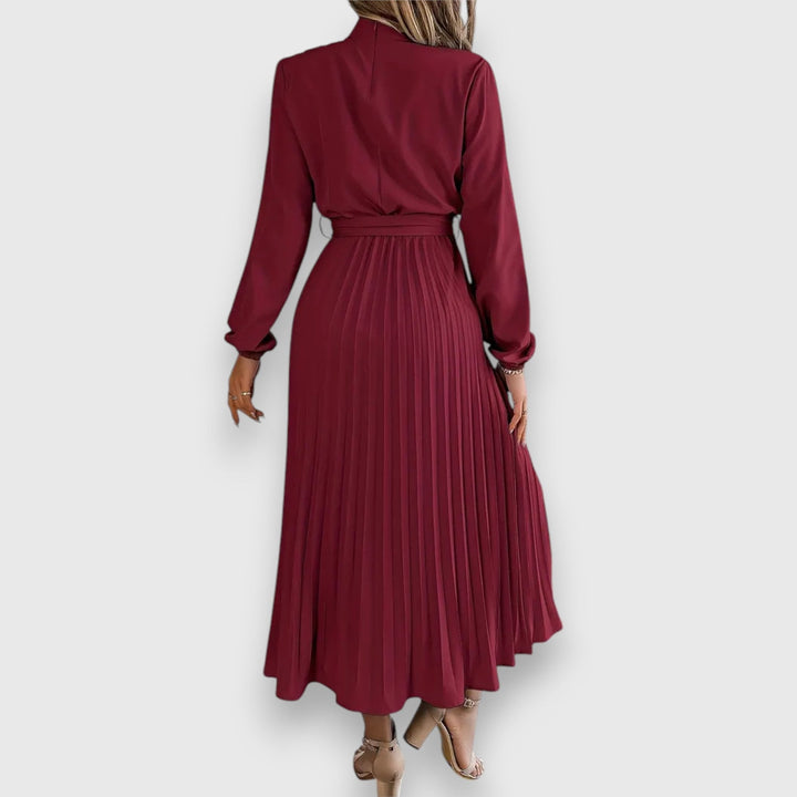 Flat lay of elegant pleated midi dress in beige highlighting fabric texture