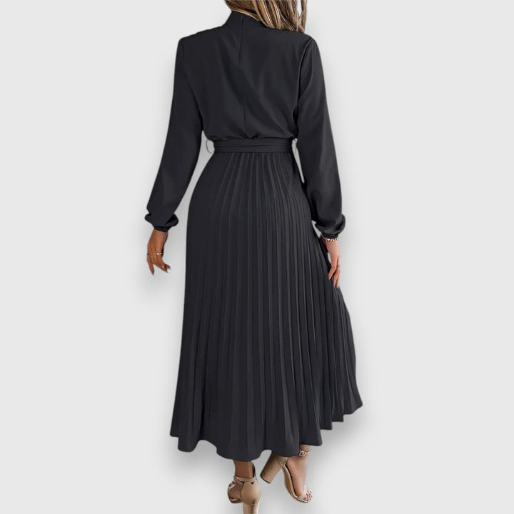 Back view of elegant pleated midi dress in black showing clean, polished design