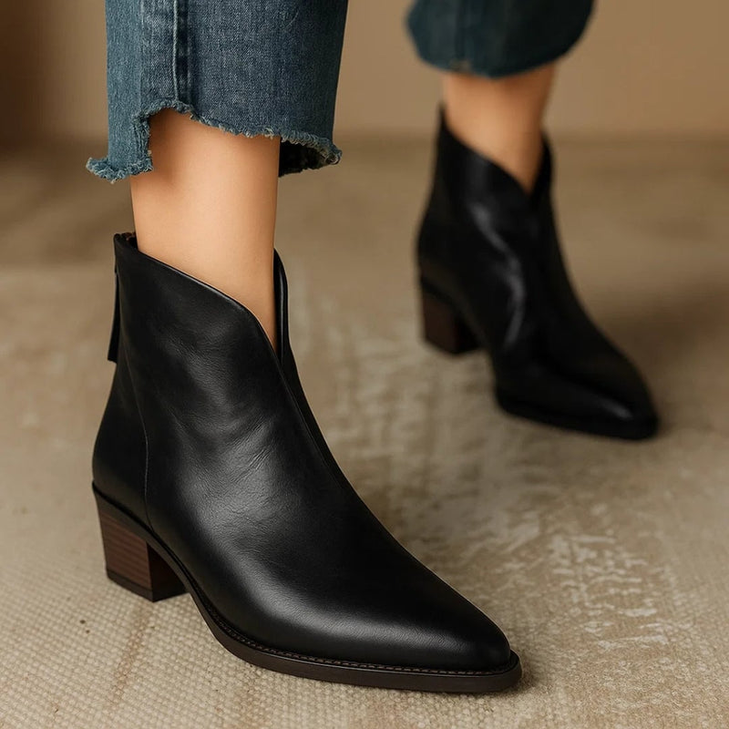 Front view of Rebecca black leather ankle boots on a neutral background
