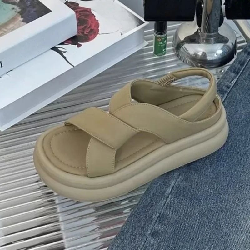 Woman wearing Reese khaki wedge sandals paired with wide-leg trousers
