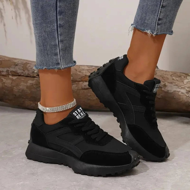 Reeve retro runner sneakers in black with mixed-texture upper and ridged outsole, front three-quarter view