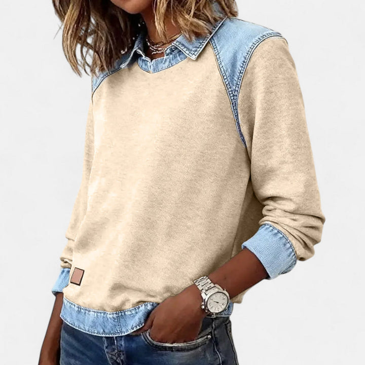Woman layering the gray Regina long sleeve sweater under a coat for a cozy transitional season look