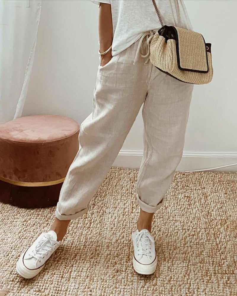 Model wearing lightweight high-waist straight-leg trousers with a soft waistband, shown in a relaxed everyday outfit