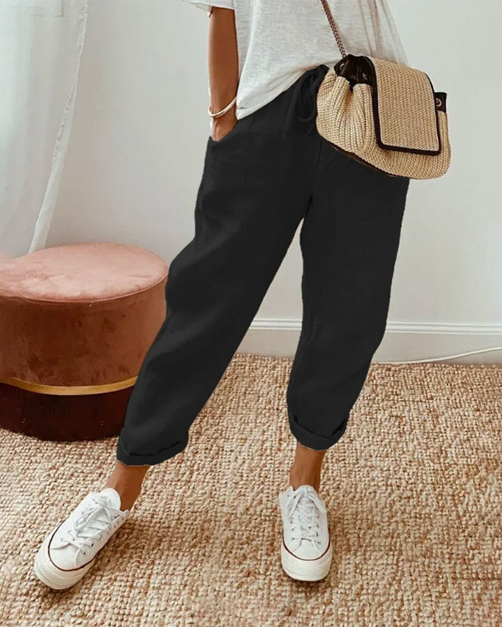 Close-up of the smooth cinched waistband and flowing fabric on casual high-waist trousers