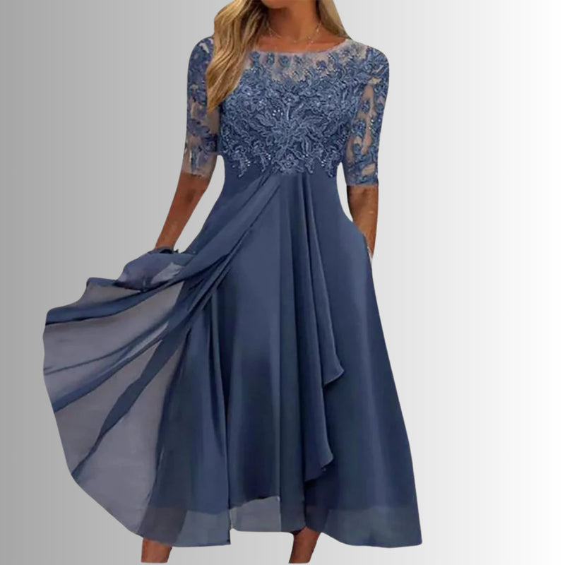 Woman wearing the Rhonda elegant lace dress in blue with a delicate lace bodice and flowing layered skirt