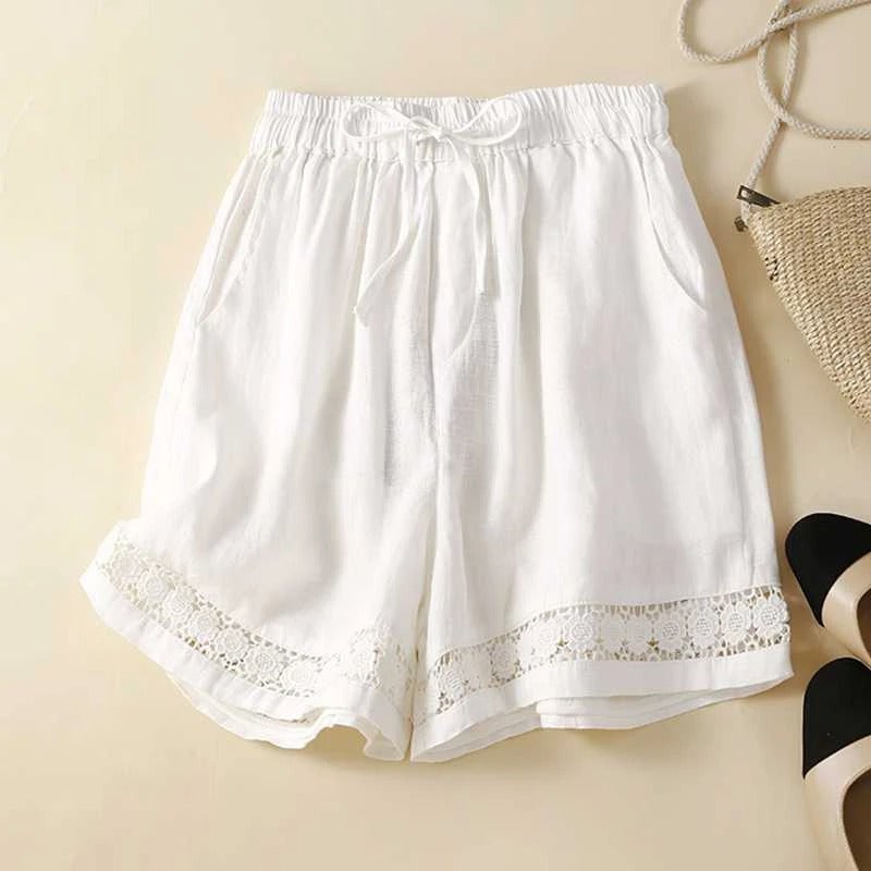 Woman wearing relaxed white floral shorts with a delicate embroidered hem, styled with a casual summer top